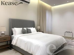um quarto com uma cama grande e lençóis brancos em Kease Hittin B-5 Elegance AG32 em Riyadh