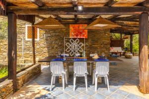 un patio con tavolo, sedie e parete in pietra di La Villa Del Paradiso a Stintino