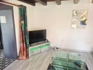 a living room with a tv and a glass table at appartement atypique en triplex in Luze