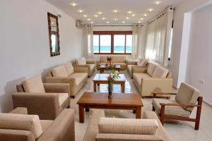una gran sala de estar con sofás y una mesa. en Niros Beachfront Aparthotel en Kokkíni Khánion