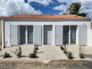 a white house with shuttered windows at Studio 2 proche bord de mer 5 mn à pied in Angoulins-sur-Mer