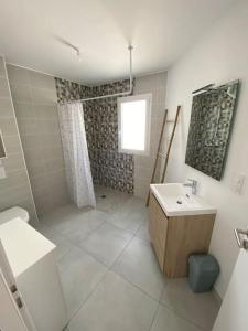 a white bathroom with a shower and a sink at Studio 2 proche bord de mer 5 mn à pied in Angoulins-sur-Mer
