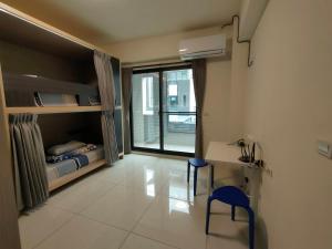 1 dormitorio con cama, escritorio y ventana en Carlos Backpacker en Minxiong
