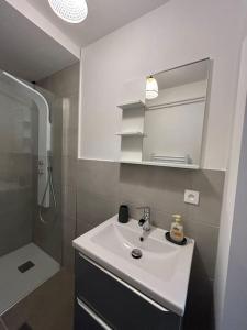 a white bathroom with a sink and a shower at Appartement Chez Maria in Guebwiller +10 photos