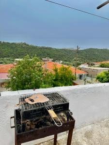 Gokceada Town的住宿－Denize 2 km Manzaralı ve Ferah 2+0 Daire (Konum Eşelek Köyü)，坐在白色墙壁上的一个烤架