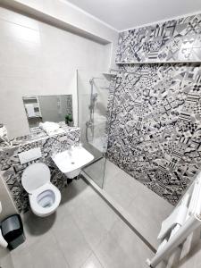 a bathroom with a shower and a toilet and a sink at ZETH HOUSE in Mamaia Sat/Năvodari +14 photos