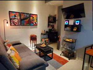 uma sala de estar com um sofá e uma televisão de ecrã plano em StudioRD Copacabana 250m da praia esquina com a Rua do Copacabana Palace Rodolfo Dantas no Rio de Janeiro