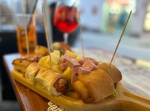 a bunch of sandwiches on a table with a glass of wine at Hotel Punto Azzurro in Ischia