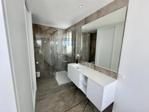 een badkamer met een witte wastafel en een spiegel bij Feelgood Homestay Sagres in Sagres +27 foto's