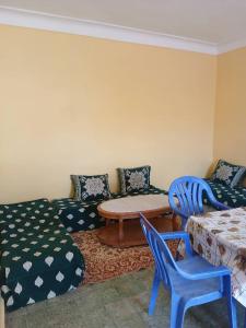 un soggiorno con divano, tavolo e sedie di Maison Bouzedjar a Douar el Msaïd