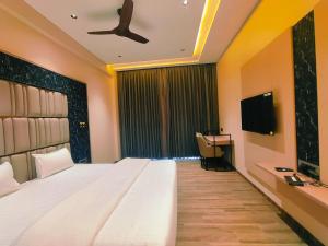 Una televisión o centro de entretenimiento en Hotel Akshay Palace Ahmednagar