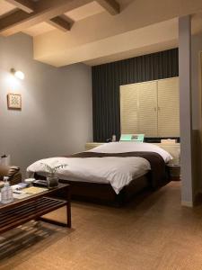 - une chambre avec un grand lit et une table dans l'établissement Valentine (Adult Only), à Tottori