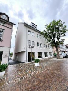 a white building with a tree in front of it at SmartApart Julia in Tettnang