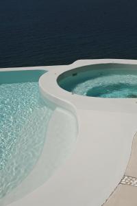 a toilet sitting in a bath tub next to the ocean at Mykonos Pantheon in Kalo Livadi