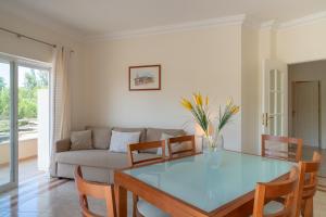 ein Wohnzimmer mit einem Glastisch und einer Couch in der Unterkunft VILAMOURA Two Bedroom Near Praia Falésia in Quarteira
