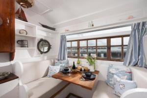 a living room with a table in a boat at Ship Ashore in Penzance