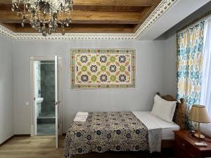 1 dormitorio con cama y alfombra en la pared en B-House Hotel, en Bukhara