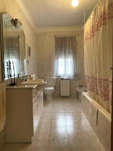 a bathroom with a sink and a tub and a toilet at Casa Justo in Apiés