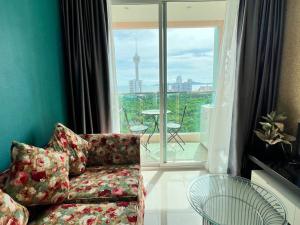 a living room with a couch and a large window at Grande Cariibbean Pattaya by Thita in Pattaya South