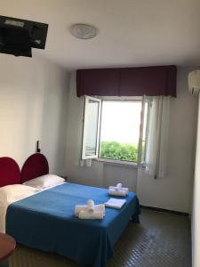 1 dormitorio con 1 cama con 2 toallas en Hotel L&V, en Rímini