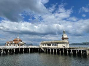 a pier with a lighthouse on the water at Dunoon River Clyde Flat in Innellan