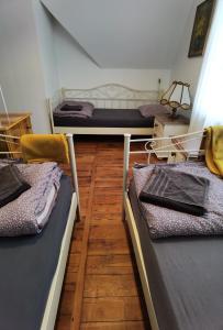 3 Betten in einem Zimmer mit Holzböden in der Unterkunft Dom Pracy Twórczej Muchomorek in Peterswaldau