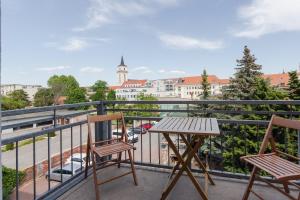 d'un balcon avec deux chaises et une table. dans l'établissement Spa Apartment am Bauhausmuseum, à Dessau
