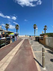 an empty street with palm trees on a beach at Appartement T2 proche plage pour 4 personnes - 4CARIO7 in Canet-en-Roussillon