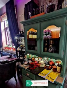 een groene kast met eten en drinken op een aanrecht bij Hotel style rooms & restaurant Pirocanac in Pirot