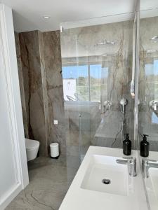 een badkamer met een wastafel en een douche bij Feelgood Homestay Sagres in Sagres