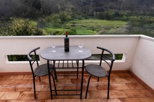 a table and chairs with a bottle of wine on a balcony at Appartamento Casa Bruna ad Arbus in Arbus