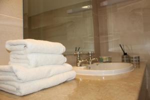 Una pila de toallas sobre un mostrador junto a un lavabo. en Aran View Country House and Lodge, en Doolin