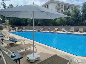 een zwembad met stoelen en een parasol naast een zwembad bij Mert Seaside Hotel in Marmaris +18 foto's