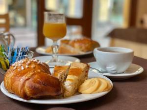 a table with two plates of pastries and a cup of orange juice at Hotel Da Raffaele in Ischia