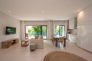 Una gran sala de estar con un sofá y una mesa. en Luxueux Appartement 3 Chambres situé à La Pointe, en Grand Baie