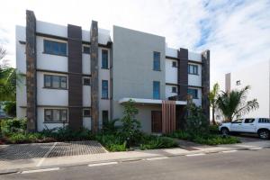 un edificio con un coche aparcado delante en Luxueux Appartement 3 Chambres situé à La Pointe, en Grand Baie