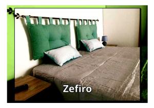 a bedroom with a large bed with green pillows at Casa Vacanze VALEDORA in Ponza