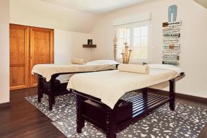 two beds in a room with a rug at Domaine Les Saules Hôtel Restaurant Spa in Favières