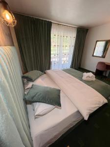 um quarto com 2 camas com almofadas verdes e brancas em Top Mountain em Poiana Brasov
