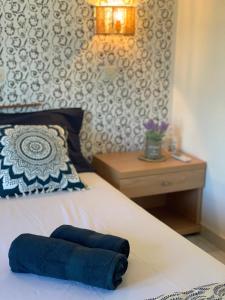 a bed with a blue towel laying on it at Skopelos Inn in Stafylos