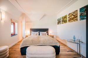 ein Schlafzimmer mit einem großen Bett und einem Stuhl in der Unterkunft Schloss Ranzow - Hotel & Appartements in Lohme