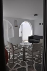 sala de estar con mesa, sillas y sofá en Alexandra Mykonos Port en Mykonos