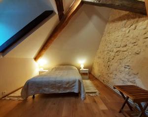 um quarto com uma cama num sótão com 2 candeeiros em Domaine Moulin de Boiscorde 1h45 Paris em Rémalard