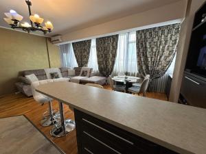 a kitchen and living room with a couch and a table at Luxury Nordic 46 Apartment in Suceava
