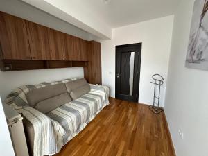a living room with a couch and wooden floors at Luxury Nordic 46 Apartment in Suceava