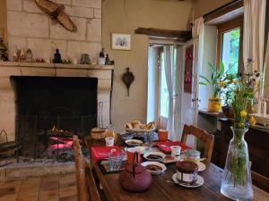 uma sala de jantar com uma mesa e uma lareira em Domaine Moulin de Boiscorde 1h45 Paris em Rémalard