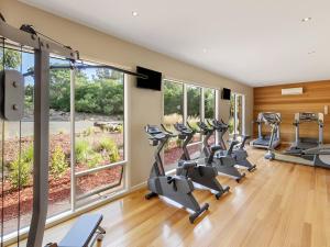 a gym with a row of treadmills and ellipticals at The Point Villa in Cowes