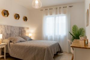 Schlafzimmer mit einem Bett und einem Fenster in der Unterkunft Apartamento Biznaga in Alhaurín de la Torre