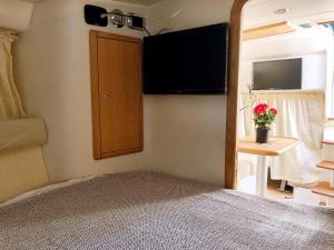 a bedroom with a bed and a tv on the wall at CRUISE BY PORTO RAFTI in Porto Rafti