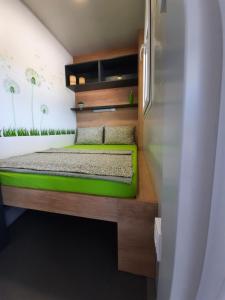 a bedroom with a green bed in a room at Mobile home Sirena Drage in Drage